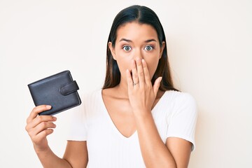 Sticker - Young beautiful latin girl holding leather wallet covering mouth with hand, shocked and afraid for mistake. surprised expression