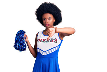 Poster - Young african american woman wearing cheerleader uniform holding pompom looking unhappy and angry showing rejection and negative with thumbs down gesture. bad expression.