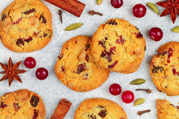 Wall Mural - Freshly baked homemade cookies with cranberries, almonds, white chocolate and spices (cinnamon, cardamom, cloves, star anise) close-up. Oatmeal biscuits. Christmas, New year. Selective focus