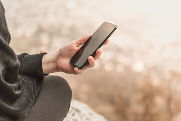 Closeup image of female hands using smartphone in mountain day, search or social network concept, hipster woman typing a sms message to her friends