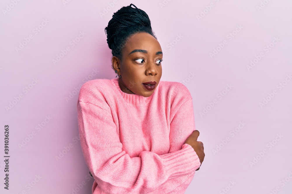 Young african american woman wearing casual winter sweater shaking and freezing for winter cold with sad and shock expression on face