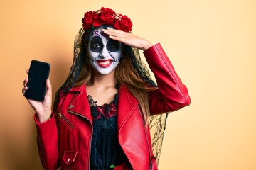 Sticker - Woman wearing day of the dead costume holding smartphone showing screen stressed and frustrated with hand on head, surprised and angry face