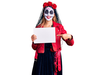 Sticker - Woman wearing day of the dead costume holding blank empty banner smiling happy pointing with hand and finger