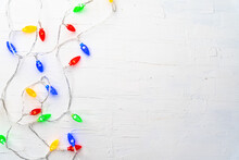 Overhead Shot Of Colorful Christmas Lights On White Surface With Space For Your Text