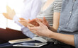 © Iryna - Business people clapping at meeting or conference, close-up of hands. Group of unknown businessmen and women in sunny office