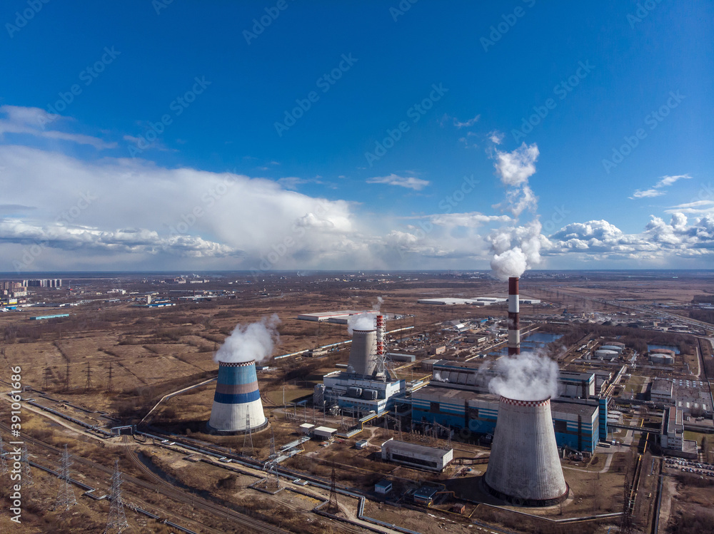 Industrial factory buildings and smoking chimney pipes. Combined heat ...