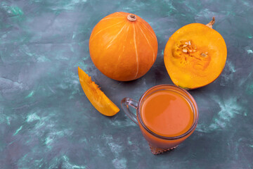 Wall Mural - pumpkin juice in a glass and pumpkin on a dark background