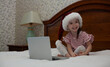 © Артем Барынин - Little girl talking and happy New Year on a laptop. Online congratulations.