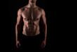 © Anetta - Muscular male torso of fit bodybuilder on black background
