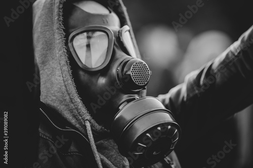 Fotografía Shallow depth of field (selective focus) image with a protestor wearing a hoodie and a military gas mask