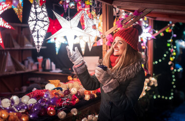 woman buying decoration and baubles on christmas market
