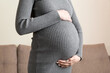 © sosiukin - Pregnancy woman in beautiful dress standing on the home