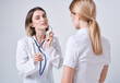 © SHOTPRIME STUDIO - doctor with a stethoscope examines a woman in a white t-shirt on a light background