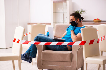 Young male student preparing for exams during pandemic at home