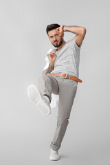 Wall Mural - Fashionable young man on grey background