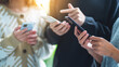 © Farknot Architect - Group of young people using and looking at mobile phone together