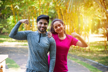 Indian healthy young couple exercising, stretching jogging or running in sportswear outdoors