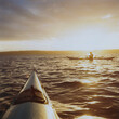 © Mint Images - Person sea kayaking at dusk