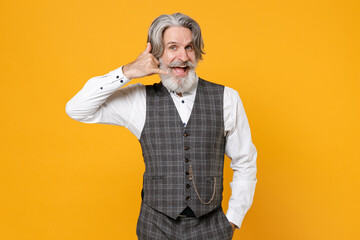 Excited elderly gray-haired business man in checkered suit waistcoat shirt doing phone gesture like says call me back isolated on yellow background studio portrait. Achievement career wealth concept.