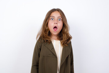 Expressive facial expressions. Shocked stupefied Beautiful little girl standing against white background, , keeps jaw dropped feels stunned from what he sees aside.