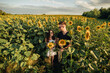© Andriy Medvediuk - Beautiful couple having fun in sunflowers field. A man and a woman in love walk in a field with sunflowers, a man hugs a woman. selective focus
