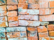 Stacks Of Old Red Brick Pavers Piled High, Recycling Icon On A Pile Of Red Bricks From A Construction Site, Sort And Recycle Waste Building Materials.