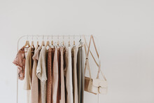 Women's Minimal Fashion Pastel Clothes. Stylish Female Blouses, Sweaters, Pants, Jeans, T-shirts, Handbags On Hanger On White Background. Fashion Blog, Website, Social Media Hero Header.