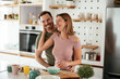 © JustLife - Young couple making sandwich at home. Loving couple enjoying in the kitchen.