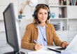 © JackF - Smiling female operator talking with customer using headset at company office