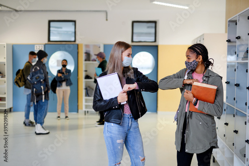Fotomural Young students friends greeting back at college or university, coronavirus concept