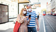 © Halfpoint - Senior couple with smartphone on bus stop outdoors in city or town, coronavirus concept.