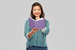 © Syda Productions - people, ethnicity and portrait concept - happy asian young woman reading book over grey background