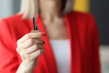 Woman In Red Suit Holding Steel Key In Office Close-up. Working In Real Estate Agency Concept