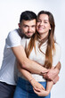 © paffy - Smiling young couple hugging, studio portrait over light background
