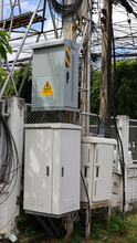 Electrical Control Socket And NODE Cabinet On Poles. Fiber Optic Junction Box Of High Speed Internet On The Side With Cement Fence Reinforced With Steel Frame. Selective Focus
