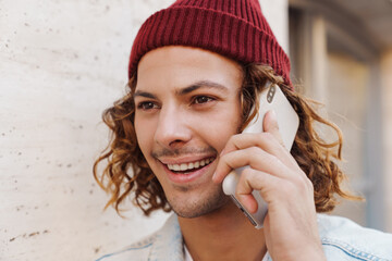 Sticker - Happy young curly man talking by mobile phone