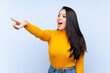 © luismolinero - Young Colombian girl over isolated blue background pointing away