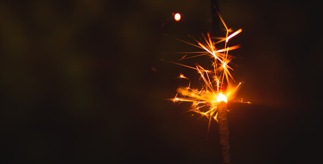 Wall Mural - Very beautiful sparkler and sparkles new year photo christmas and holiday on a dark black background banner