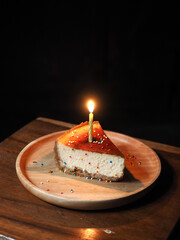 Wall Mural - a piece of confetti cheesecake with lighted candle