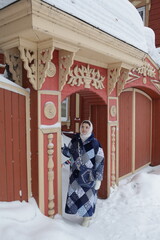 Wall Mural - Russian woman. Carved gate, door of old wooden house on Tatarskaya Street, 1 Tomsk city, Russia. Russian folk style in architecture, seasonal fashion. Cold season, snow, snowy winter. Tomsk landmark