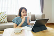 © zasabe - Asian woman aged 30-35 years using tablet, watching lesson Sign language online course communicate by conference video call from home, e-learning education concept
