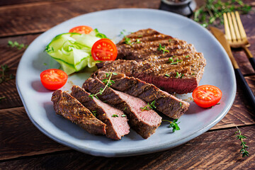 Wall Mural - Grilled juicy steak medium rare beef with spices and fresh salad.