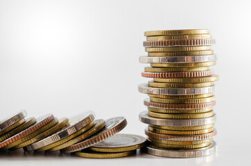 row of coin stack growing pile on white background for money saving and investment business financial and banking concept.