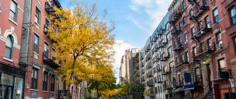 Panoramic view of historic buildings along 15th Street with colorful fall trees in the Chelsea neighborhood of New York City - obrazy, fototapety, plakaty 