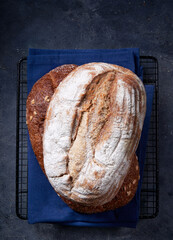 Two fresh homemade artisan breads stacked on dark gray surface. Top view. Copy space. Bread bakery background.