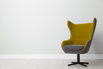 Comfortable office chair near light wall indoors. Space for text