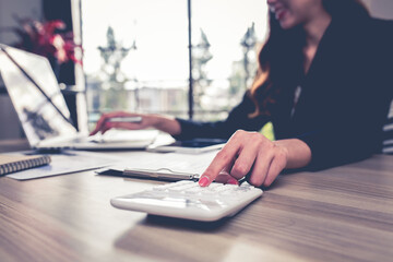 Young business woman are working with a calculator and laptop in office account business finance concept.