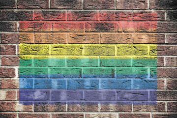 Gay pride rainbow flag on brick wall background