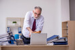© Elnur - Aged male employee unhappy with excessive work