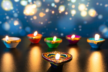 Wall Mural - Indian festival Diwali, Diya oil lamps lit on colorful rangoli. Hindu traditional. Happy Deepavali. Copy space for text.